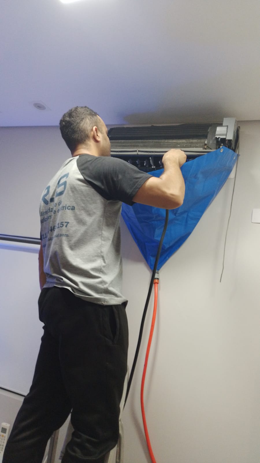 Técnico da RS Climatização higienizando um ar-condicionado split